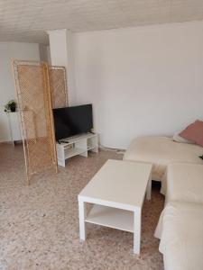 a living room with a couch and a tv at Apartamento Bellreguard Playa in Playa de Miramar