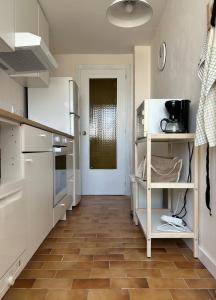 a kitchen with white appliances and a wooden floor at Apartamento Bellreguard Playa in Playa de Miramar