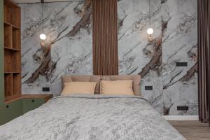 a bedroom with a bed and a marble wall at Exclusive Apartment 2 in Chişinău