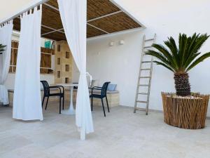 a room with a table and chairs and a palm tree at Annina guest house soggiorno vista mare in Savelletri di Fasano