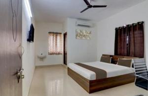 a bedroom with a bed with a ceiling fan at Serene Residency 1BHK SkylineView by Homeyhuts in Lingampalli