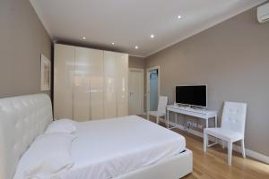 a bedroom with a bed and a desk and a television at Brezza Marina in Lido di Ostia