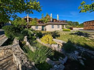 a house with a stone fence in front of it at Eco-selo Grabovica in Grabovica