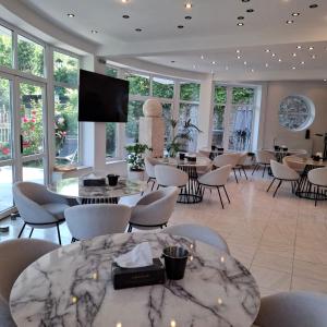 a large room with tables and chairs and a flat screen tv at Pensiunea Warthe Bed & Breakfast in Braşov