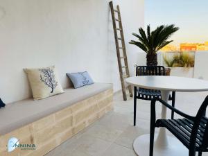 a room with a bench and a table and a chair at Annina guest house soggiorno vista mare in Savelletri di Fasano