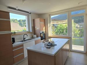 a kitchen with a counter and two windows in it at Razor Vista Apartment in Tolmin