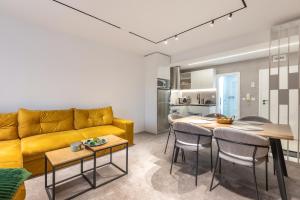 a living room with a yellow couch and a table at Mont Blanc Apartment in Bansko