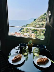 a table with two plates of food and a window at Cinque Terre, Sea View Home in Manarola