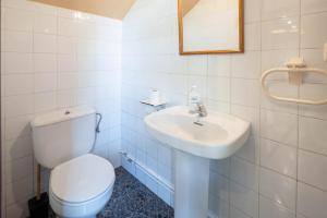 ein weißes Badezimmer mit Toilette und Waschbecken in der Unterkunft Casa da Carballeira in A Estrada + 16 Fotos