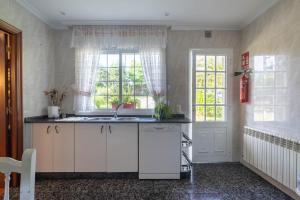 eine Küche mit Spüle und Fenster in der Unterkunft Casa da Carballeira in A Estrada