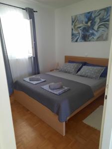 a bedroom with two beds and a window at Apartman Meli in Rab