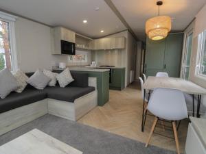 ルシンにあるWoodlands Gold WO06のソファとテーブルのあるキッチンとリビングルーム