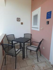 a black table and chairs in a room at Apartman Meli in Rab