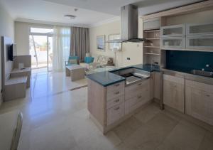 a kitchen with blue counter tops and a living room at Holiday Club Playa Amadores in Amadores