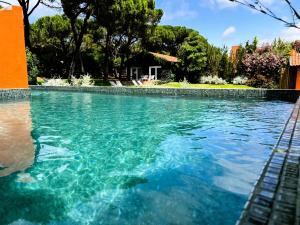a swimming pool with blue water in a yard at Quinta da Bicuda in Cascais