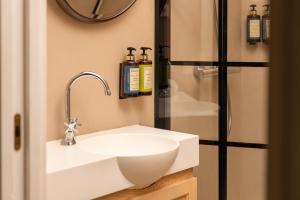 a bathroom with a white sink and a shower at Honest Sevilla Apartments in Seville