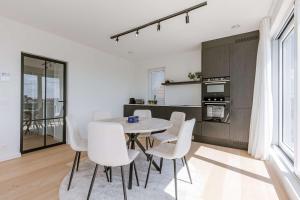 a kitchen and dining room with a table and chairs at Huswell - New Beach Apartment in De Haan in De Haan