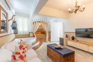 a living room with a couch and a tv and a tub at Mon Ilıca Otel in Çeşme