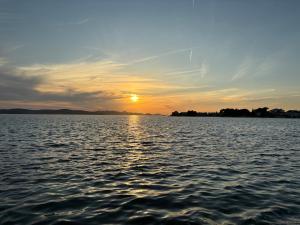 a sunset over a large body of water at Pirate's Cove in Sukošan