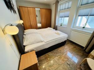 a bedroom with a bed and a table and two windows at Strandsicht, direkt am Strand in Warnemünde
