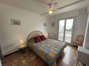 sypialnia z łóżkiem i wentylatorem sufitowym w obiekcie T2 cabine rénové, animaux admis, parking sécurisé, proche plage et port - Saint-Cyprien - FR-1-106-69 w mieście Saint-Cyprien