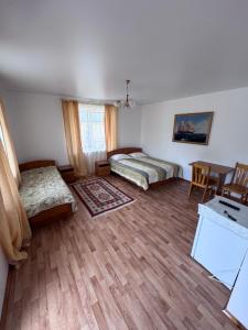 a room with two beds and a table and a desk at Meerim Murok in Bosteri