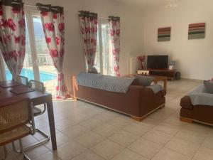 ein Wohnzimmer mit Sofa und Fernseher in der Unterkunft Villa Eros in Zóla