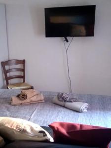 a room with a bed with a tv and a chair at A casa di Carmela in Arpino