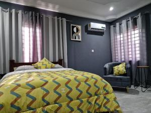 KwabenyaにあるKirpal Villaのベッドルーム(黄色と青のベッド1台、椅子付)