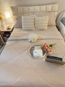 a bed with a tray of towels and a laptop on it at The Cozy Clouds Staycation in Suba