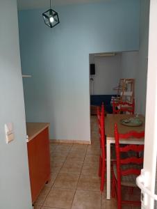 a kitchen and dining room with a table and chairs at Milto's Rooms in Himare