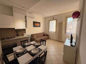 a kitchen and living room with a table and chairs at La Casetta Del Borgo in Ravenna