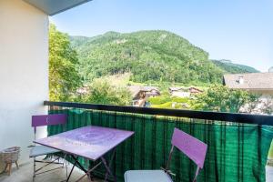 una mesa y sillas en un balcón con una montaña en Proche centre Thônes, Apt Cosy entre Lac&Montagnes, en Thônes