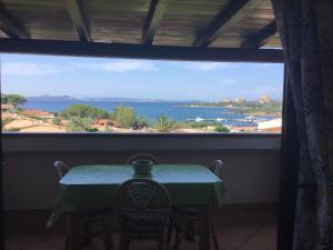 a table and chairs in a room with a large window at FABULOUS APARTMENT in COSTA SMERALDA in Cala Bitta +1 photo