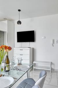 a living room with a glass table and a tv at Żywiec Apartament - Parking&Balcony - by Rentujemy in Żywiec