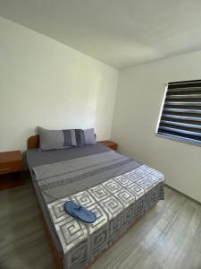 a bedroom with a bed with a blue shoe on it at Apartman Neretva 1 in Mostar