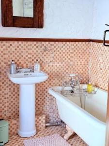 un bagno con lavandino e vasca da bagno di The Buttoned Hearth in Ullswater a Penrith