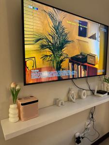 a flat screen tv hanging on a wall above a shelf at The Cozy Clouds Staycation in Suba
