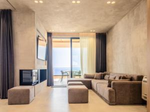 a living room with a couch and a tv at Villa 4 - Drymades - Thymus Residence in Dhërmi