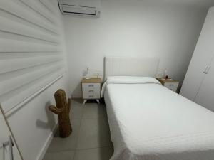 Un pequeño dormitorio blanco con una cama y una cuna. en Luxury San Jose, en San José