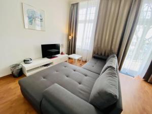 a living room with a couch and a television at Doppelzimmer Humidor, direkt am Alten Strom in Warnemünde