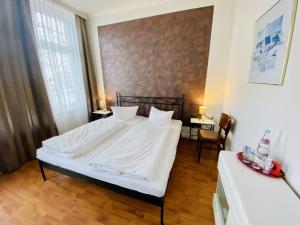 a bedroom with a large white bed and two tables at Doppelzimmer Humidor, direkt am Alten Strom in Warnemünde