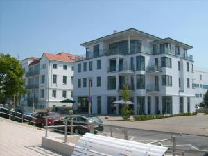 a large white building with cars parked in front of it at Marthes Seeblick in Warnemünde
