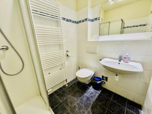 a white bathroom with a toilet and a sink at WarneSonne in Warnemünde +15 photos