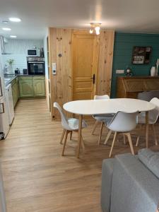 a dining room and kitchen with a table and chairs at La Rivière Sage in La Rivière-Enverse