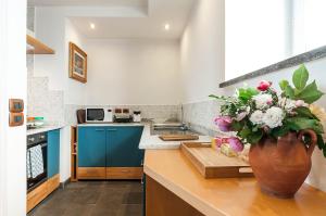 a kitchen with a vase of flowers on a counter at Villa Afrodite in Mondragone +37 photos