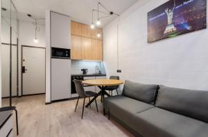 基辅Petrovdom Apartments 26-305А in RC Manhattan, 11 Beresteiskyi的客厅里有一张沙发和一张桌子。