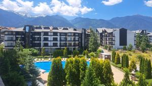 a resort with a swimming pool and mountains in the background at Pirin Views Aspen A337 in Razlog
