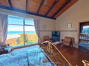 a bedroom with a bed and a large window at The Goat and Goose Bed & Breakfast in Lakes Entrance
