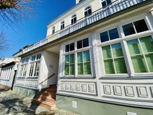 a white house with windows and a balcony at Seerose in Warnemünde